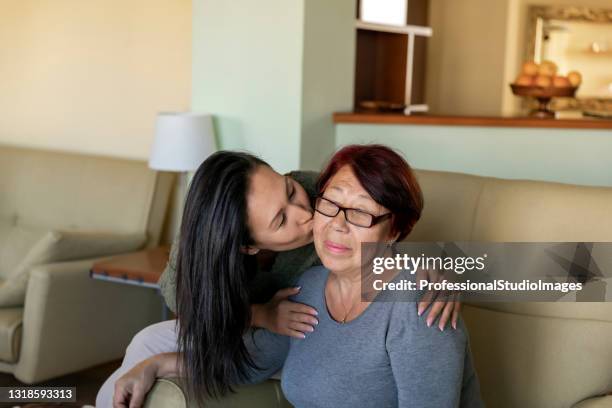 de rijpe vrouw koestert haar glimlachende moeder over haar schouder en deelt de emoties van de liefde. - chinese mothers day stockfoto's en -beelden