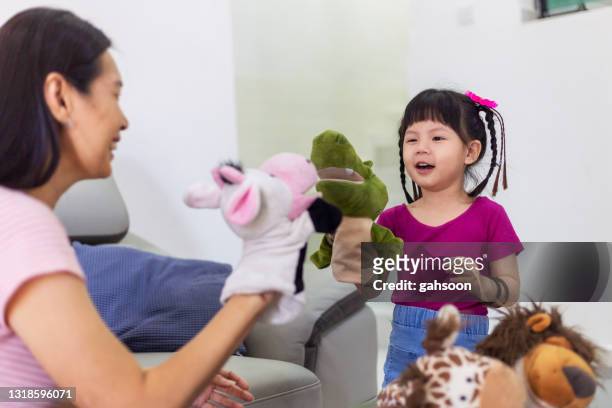 mother and toddler daughter playing with hand puppet toys - puppet show imagens e fotografias de stock
