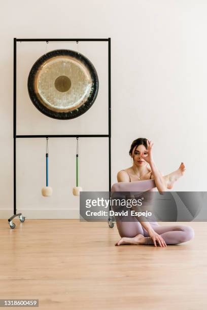 young girl doing a yoga pose in the studio - gong fotografías e imágenes de stock