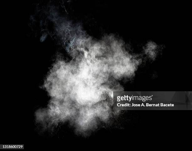 explosion of a cloud of particles of smoke of white color on a black background. - smoke physical structure stock pictures, royalty-free photos & images