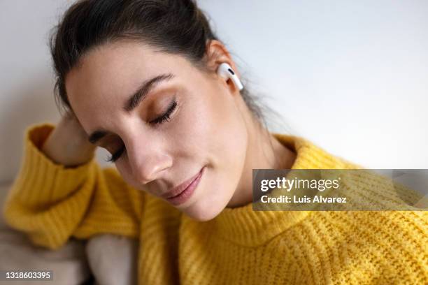 woman listening to relaxation music on her wireless earphones - erleichterung stock-fotos und bilder