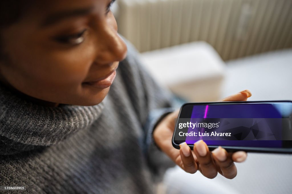 African female using voice assistant on smartphone