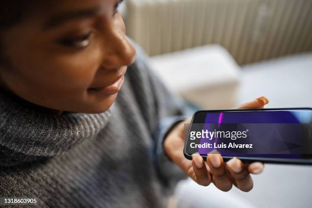 african female using voice assistant on smartphone - voice stock pictures, royalty-free photos & images