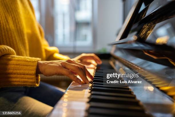 close-up of woman hands playing piano - musical harmony stock pictures, royalty-free photos & images