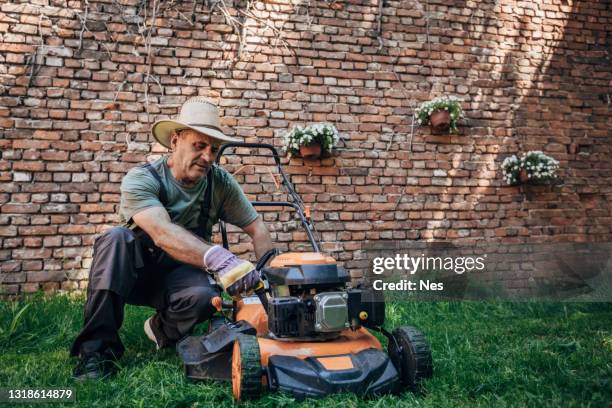 the gardener works with a lawn mower - lawn mower stock pictures, royalty-free photos & images