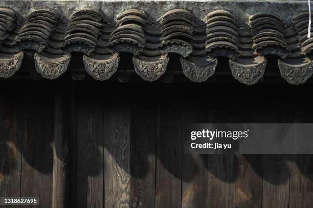 chinese-style building eaves and tiles, wooden doors. suzhou, jiangsu province, china. - eaves - fotografias e filmes do acervo