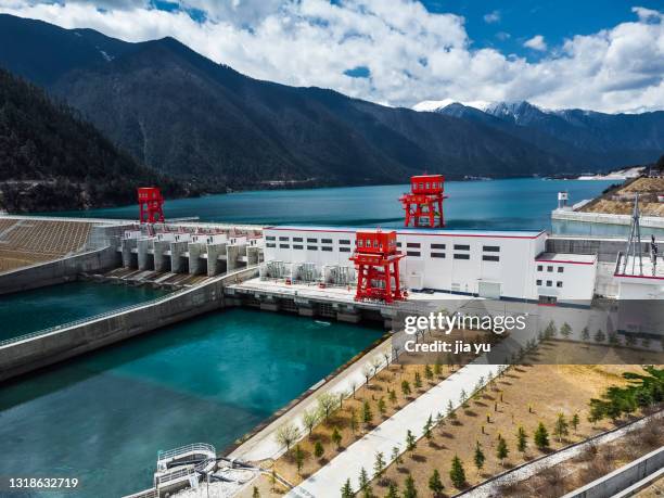 reservoir and hydropower station in mountains - ponte tibetano foto e immagini stock
