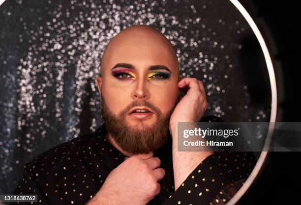 shot of a young man wearing theatrical makeup in a studio - crossdresser men stock pictures, royalty-free photos & images