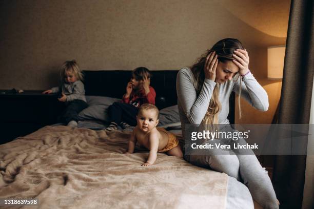 parenting and family difficulties - moms crying in bed stockfoto's en -beelden