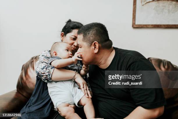 parent asiatique portant leur bébé à la maison - large family stock photos et images de collection