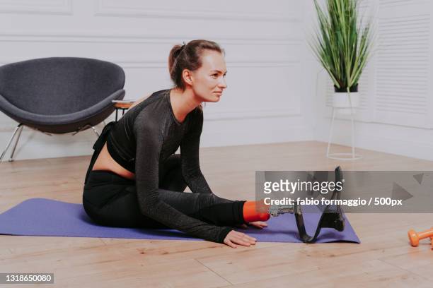 young woman using laptop while sitting on floor - diabetic amputation stock pictures, royalty-free photos & images