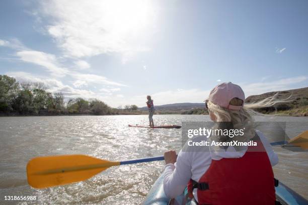 pov van vrouw kajakken langs rivier samen met paddle boarder - fruita colorado stockfoto's en -beelden