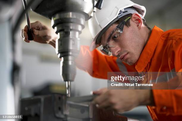 industrial engineer working and congtrol at a lathe machine in a factory. engineering part manufacturing concepts. - drill stockfoto's en -beelden