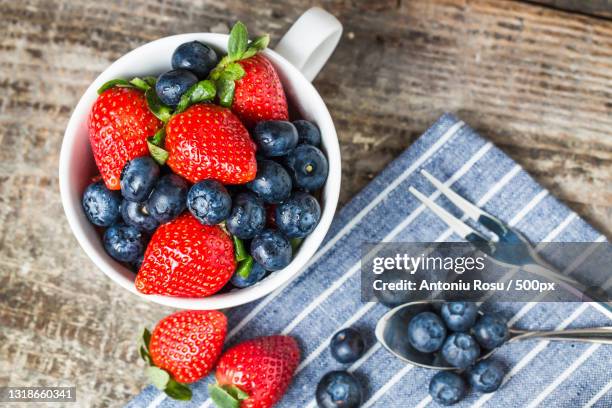 high angle view of fruits in bowl on table - fruta baya fotografías e imágenes de stock