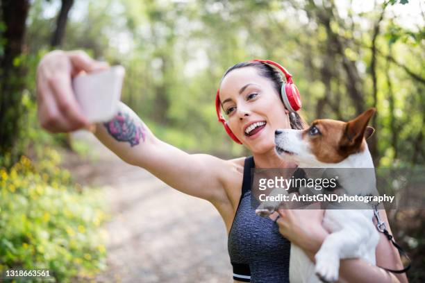年輕女子慢跑后和她的狗自拍。 - spring racing 個照片及圖片檔
