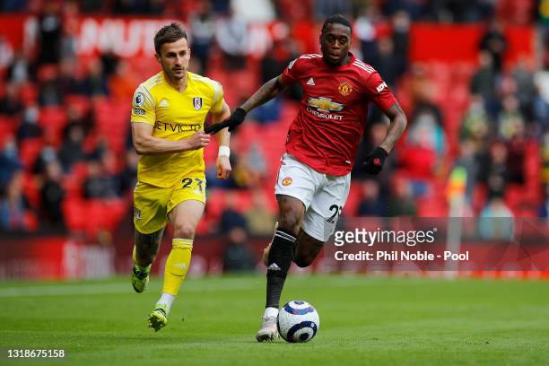 Aaron Wan-Bissaka of Manchester United runs with the ball whilst under pressure from Joe Bryan of Fulham during the Premier League match between...