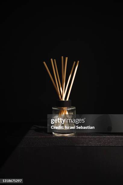 front view of an oil air freshener on a black wooden background. - perfumería fotografías e imágenes de stock