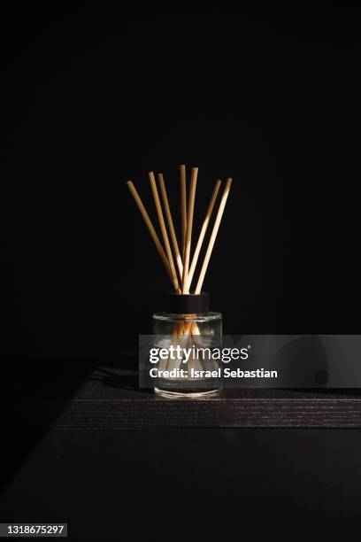 front view of an oil air freshener on a black wooden background. - luchtverfrisser stockfoto's en -beelden