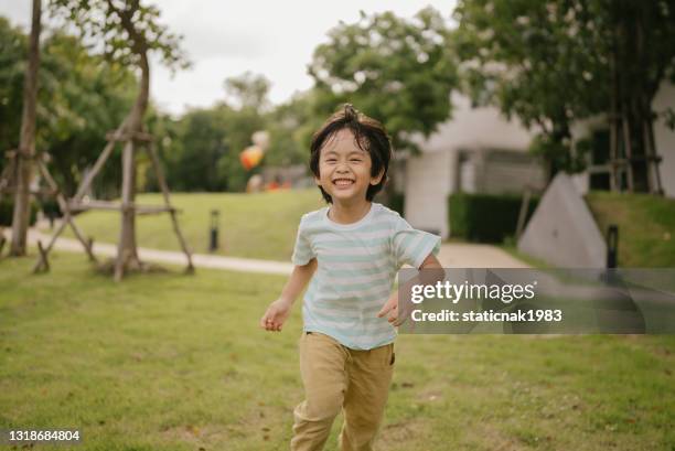 asian boy running in park. - asia kid imagens e fotografias de stock