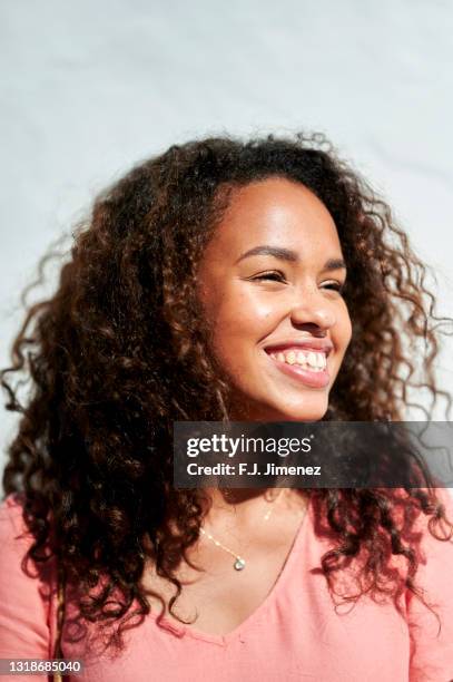 portrait of woman with curly hair in sunlight - summer skin stock pictures, royalty-free photos & images