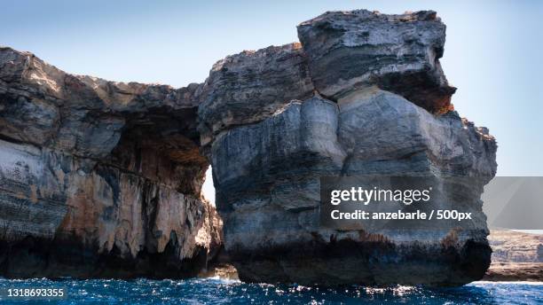 view of rock formation in sea against clear sky,gozo,malta - azure window malta stock pictures, royalty-free photos & images