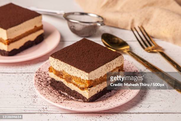 close-up of cake in plate on table - tiramisu stock-fotos und bilder