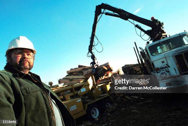 Edward App stands in front of a "Log Buster" December 13, 2000 which splits large logs into shorter pieces to be then cut into firewood at App Tree...