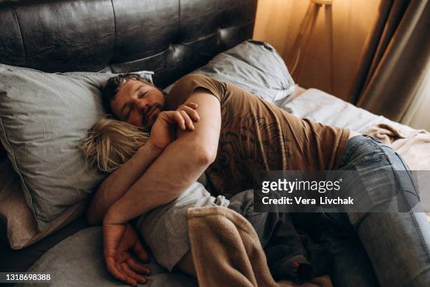 bearded father sleeps with baby in bed - human limb stock pictures, royalty-free photos & images