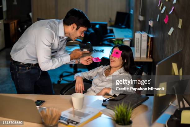 pretend to a friend who is secretly sleeping while working overtime in the office. - april fools day imagens e fotografias de stock