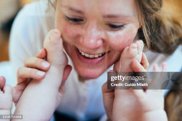 happy smiling mother and baby feet at home. - kiss foot stock pictures, royalty-free photos & images