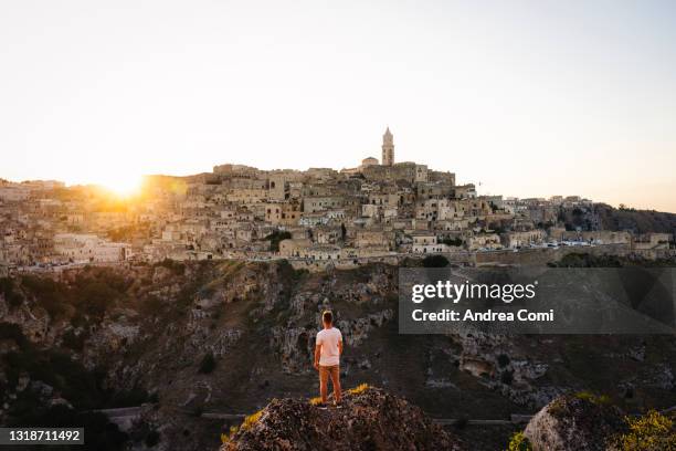 tourist admiring matera at sunset. italy, europe - matera stock-fotos und bilder