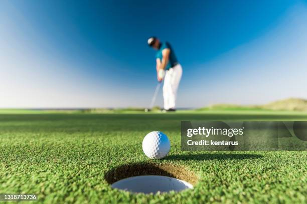 golfspeler die een succesvolle slag maakt - links golf - golfbaan stockfoto's en -beelden