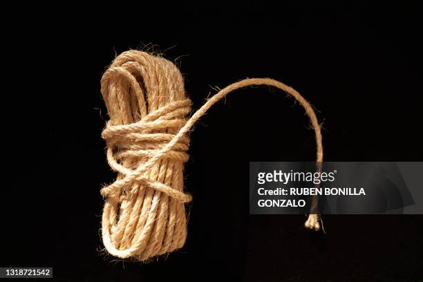 string with knot against black background - cordel imagens e fotografias de stock