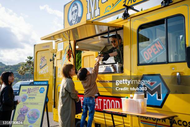 madre e figlio giovane che comprano il pranzo da un camion di cibo - furgone ambulante foto e immagini stock