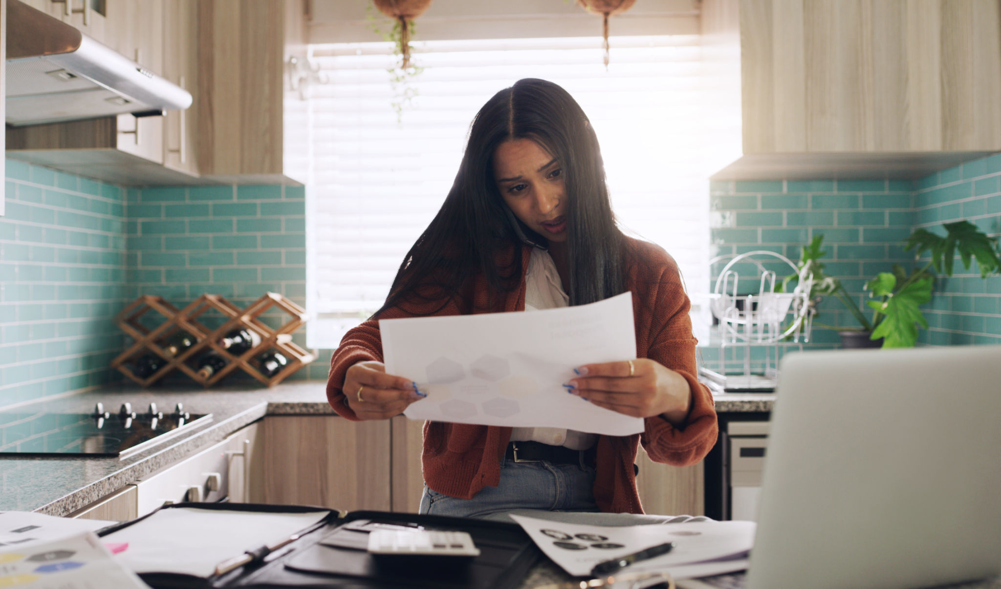 Shot of a young businesswoman taking a phone call while working at home Shot of a young businesswoman taking a phone call while working at home