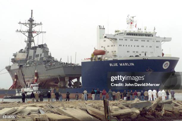 Crowd of dock workers gather as the USS Cole is returned back to the United States December 13, 2000 at Ingalls Shipbuilding in Pascagoula, MS. The...