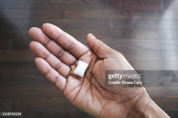 woman holds piece of sugar-free chewing gum - bubble gum stock pictures, royalty-free photos & images