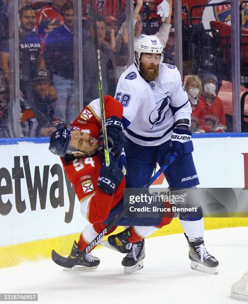 David Savard of the Tampa Bay Lightning hits Ryan Lomberg of the Florida Panthers during the second period in Game Two of the First Round of the 2021...
