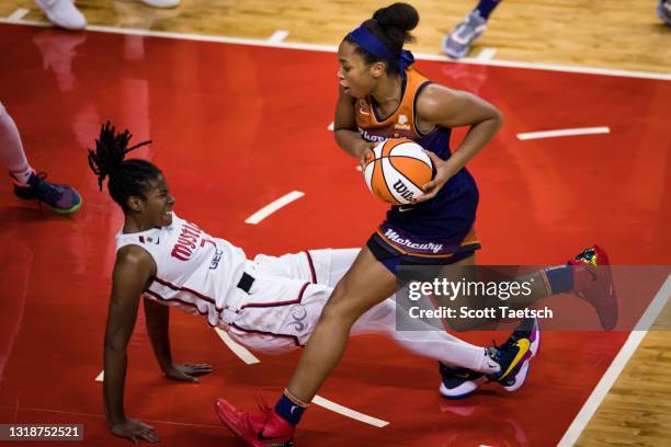 Ariel Atkins of the Washington Mystics falls to the court after being assessed with a foul against Megan Walker of the Phoenix Mercury during the...