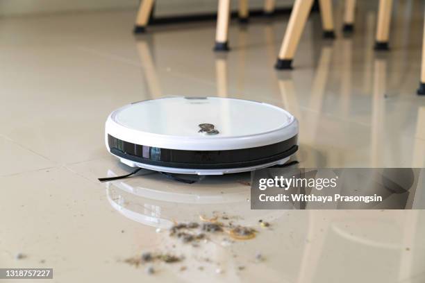 robotic vacuum cleaner on carpet in cozy living room - vacuum cleaner fotografías e imágenes de stock
