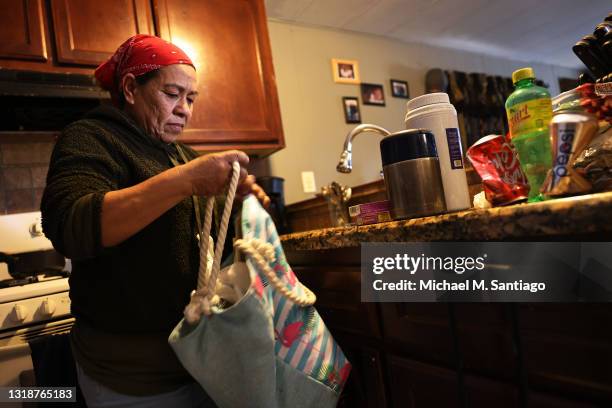 Imelda Valdivia, a farm worker originally from Michoacán, Mexico, empties her bag after arriving home from work on May 18, 2021 in Bakersfield,...