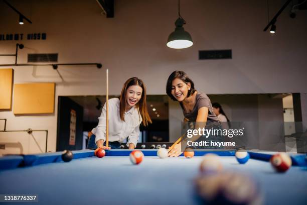 jonge vrouwenbureauarbeiders die pool in het bureau spelen - poolbiljart stockfoto's en -beelden