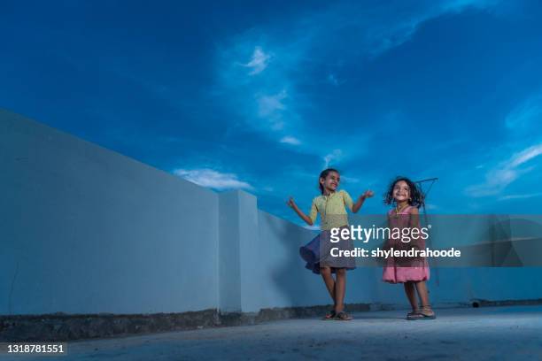 twee babymeisje dat op terras danst - children dancing outside stockfoto's en -beelden