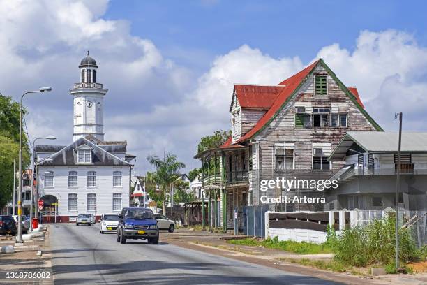 White wooden clock tower of the Ministry of Finance building and colonial houses in the city centre of Paramaribo, Suriname / Surinam.