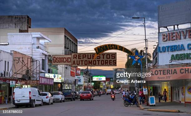 Traffic and shops in the shopping street at sunset in the city Presidencia Roque Sáenz Peña / Saenz Pena in the Chaco Province, Argentina.