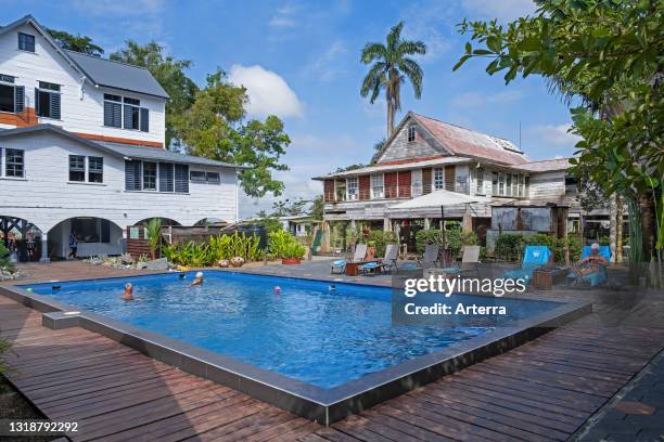 Elderly tourists in swimming pool at Boutique Hotel Peperpot, former house at coffee and cacao plantation in Commewijne District, Suriname / Surinam.