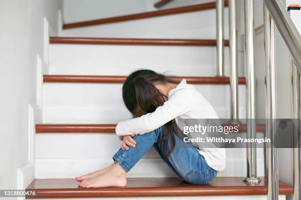 upset problem child with head in hands sitting on staircase concept - けんか ストックフォトと画像