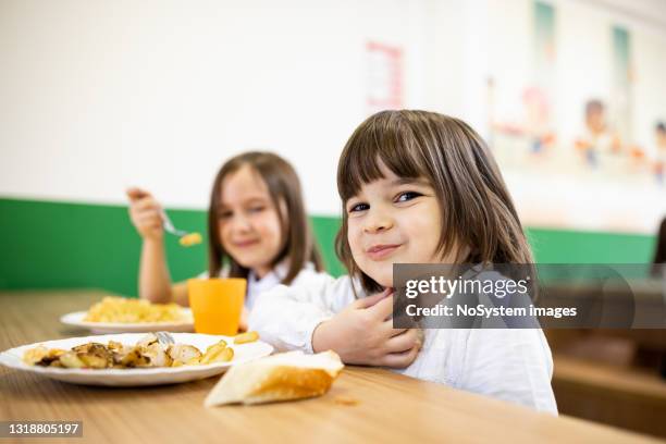 grundschulkinder in der mittagspause in der schulkantine - kantine essen stock-fotos und bilder