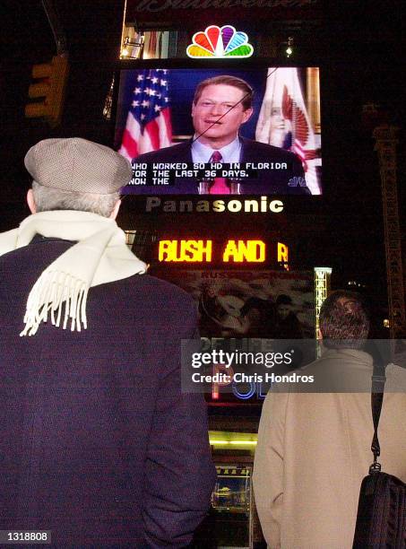 People in Times Square watch Vice President Al Gore concede the race for president to George W. Bush December 13, 2000 on a giant video screen in New...