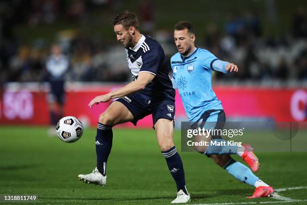 Nicholas Ansell of the Victory is challenged by Adam Le Fondre of Sydney FC during the A-League match between Sydney FC and Melbourne Victory at...